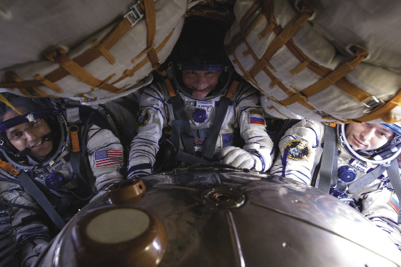 Gli astronauti Joe Acaba, Gennady Padalka e Sergei Revin a bordo della Sojuz prima del loro ritorno a terra il 17 Settembre 2012. Nel rientro in atmosfera la gravità spinge il sangue lontano dalla testa verso le parti inferiori del corpo causando capogiri. Come misura preventiva la crew indossa tute anti-G che premono sulle gambe per mantenere il sangue nella parte superiore del corpo.